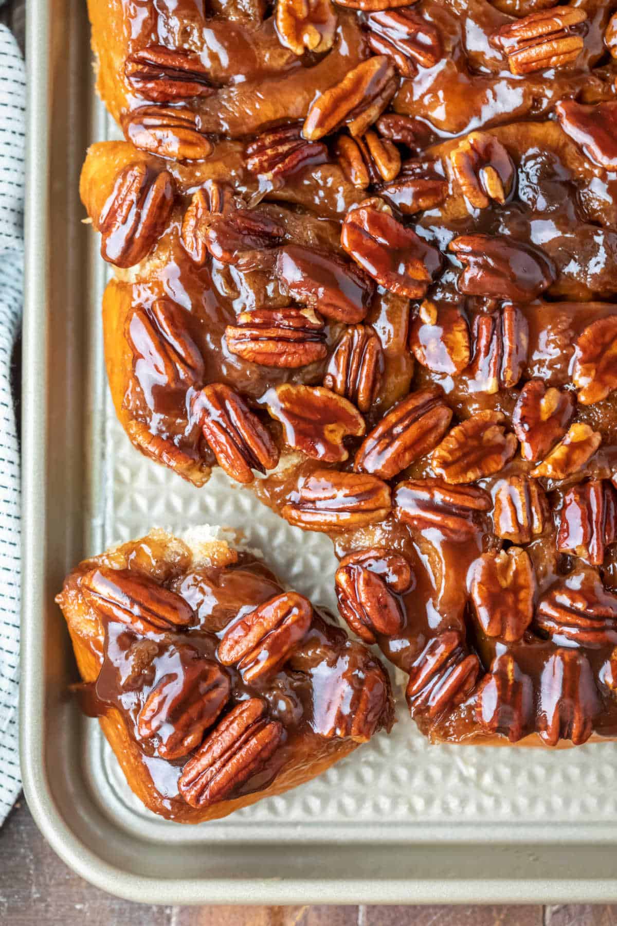 A maple sticky bun pulled away from the rest of the sticky buns.