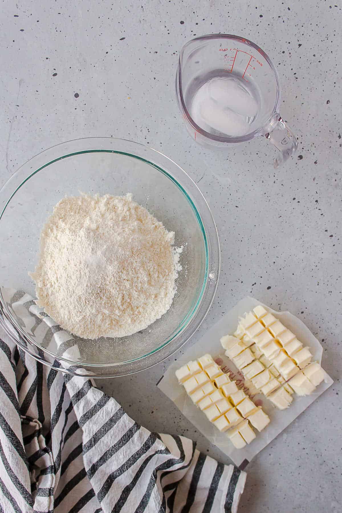 Flour cut butter and ice water in dishes. 