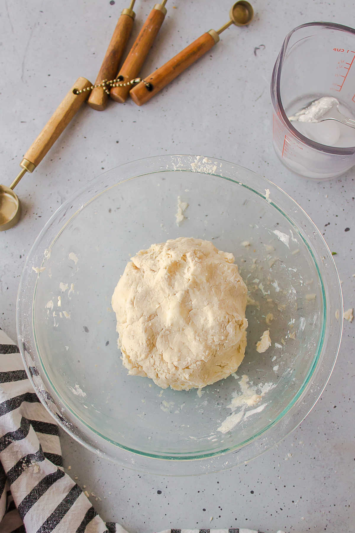 Pie dough in a glass mixing bowl. 