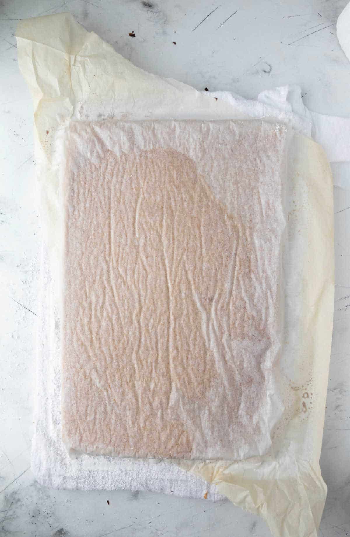 Inverted cake with a piece of parchment paper on top. 