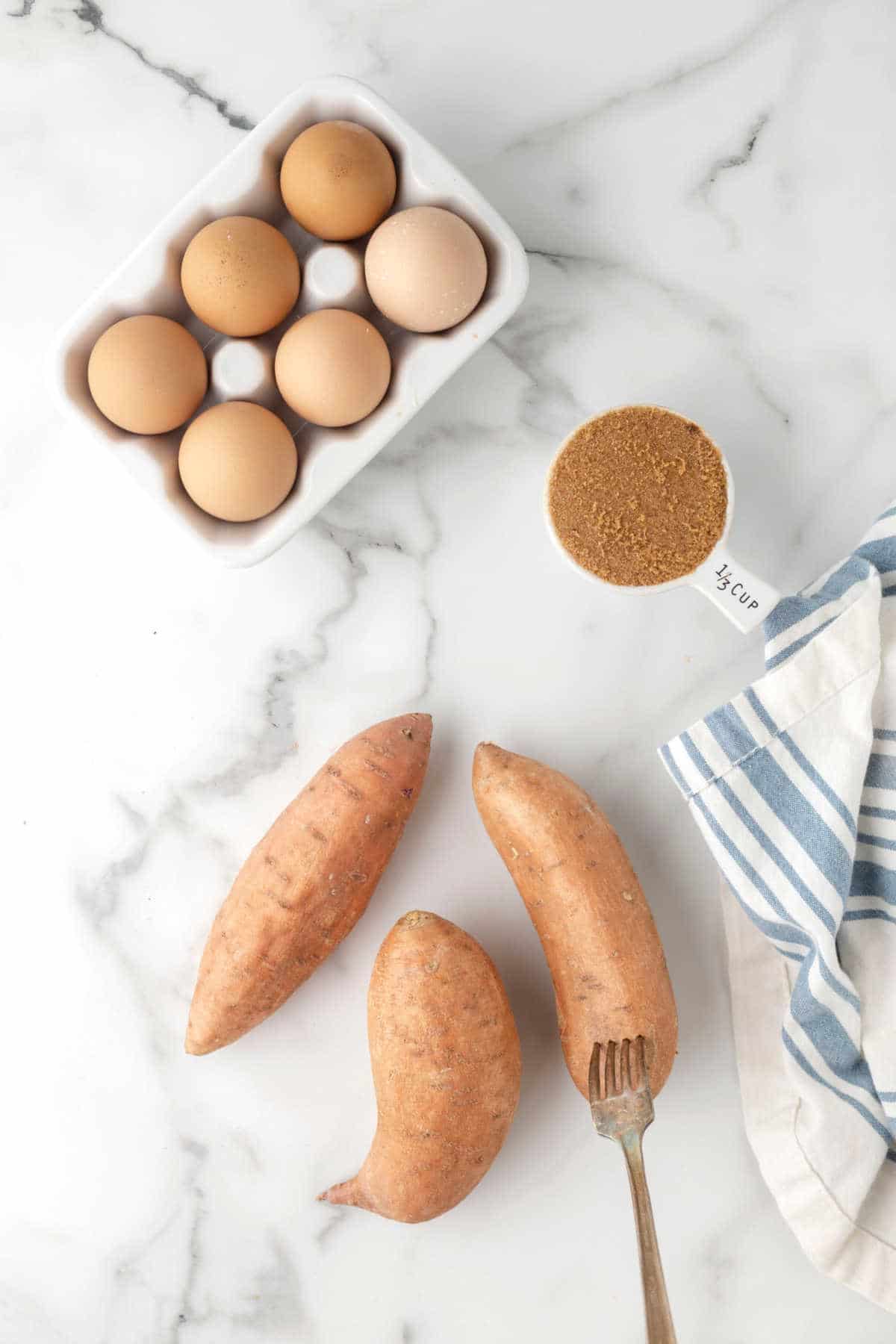 A fork poking holes in a sweet potato. 