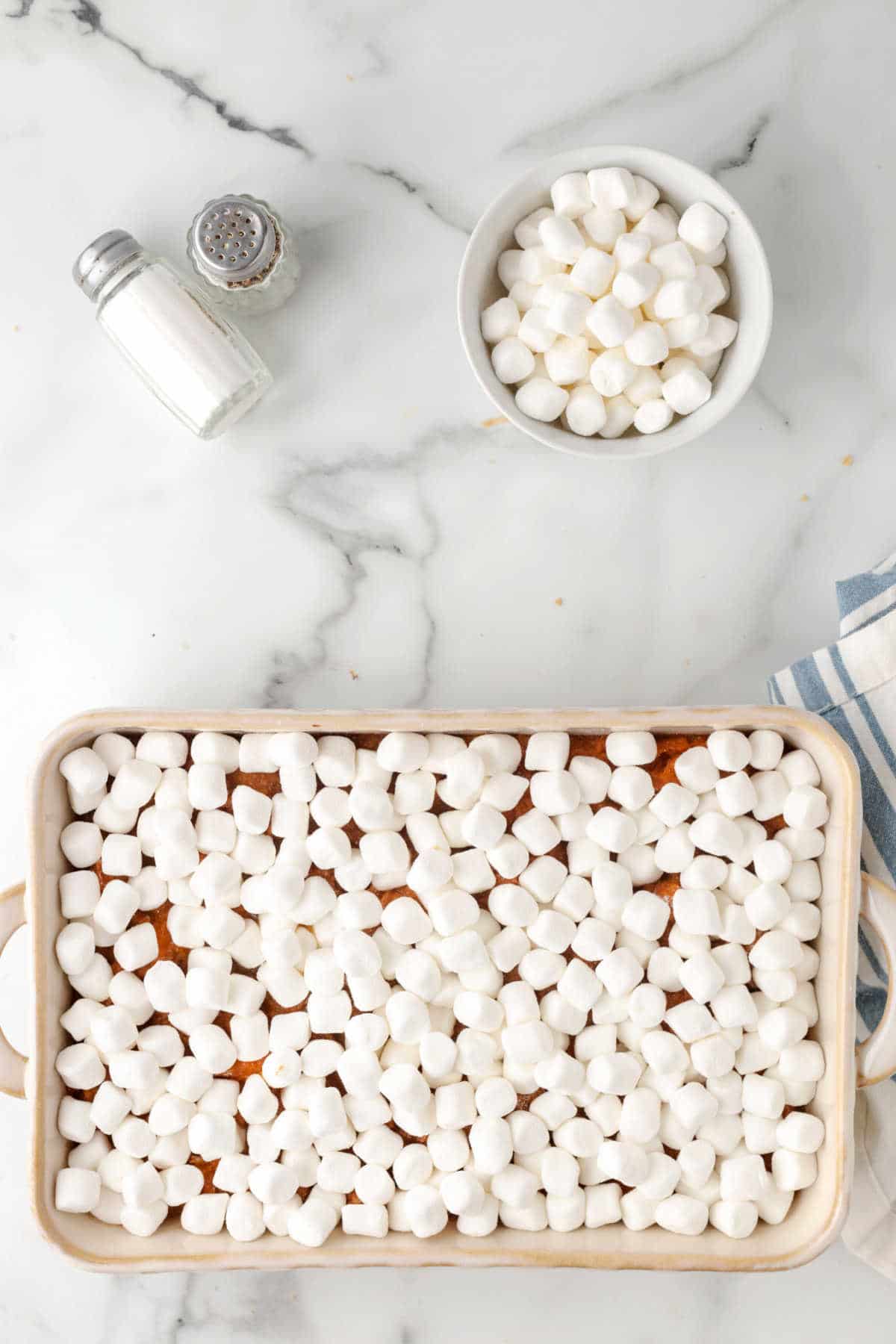Unbaked mini marshmallows on top of sweet potato casserole. 