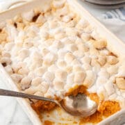 A spoon scooping out sweet potato casserole.