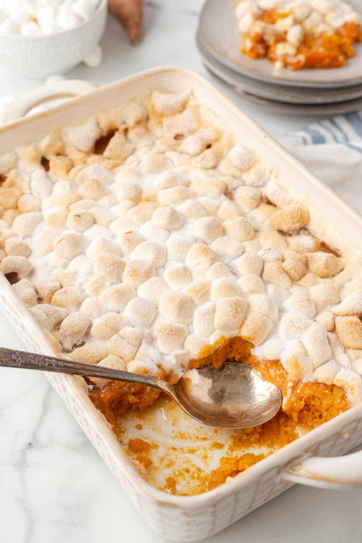 A spoon scooping out sweet potato casserole. 