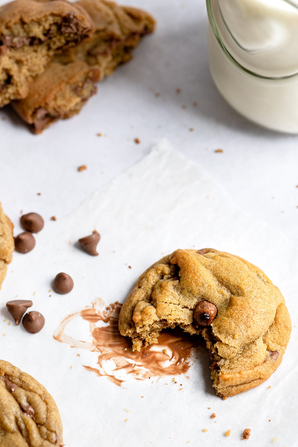 A bakery style chocolate chip cookie with a bite missing. 