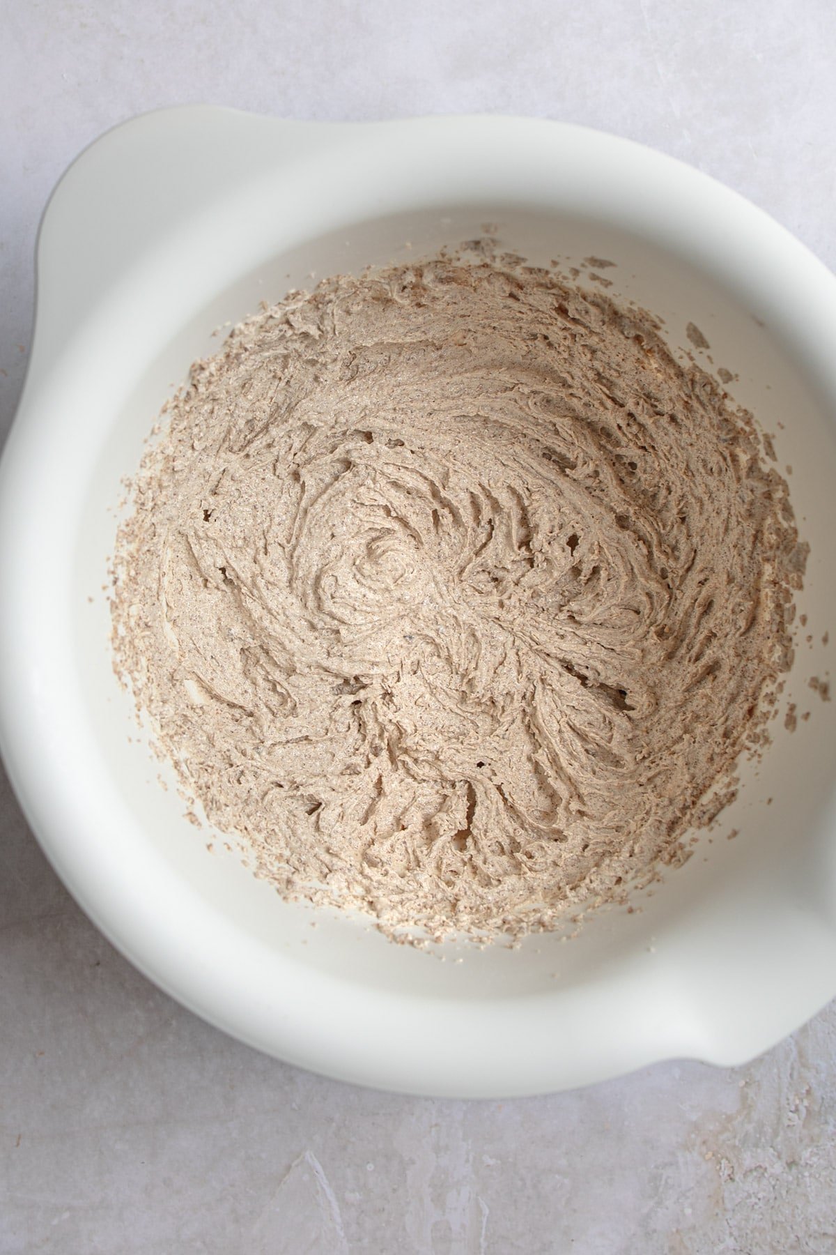 Creamed butter and sugar in a white mixing bowl. 