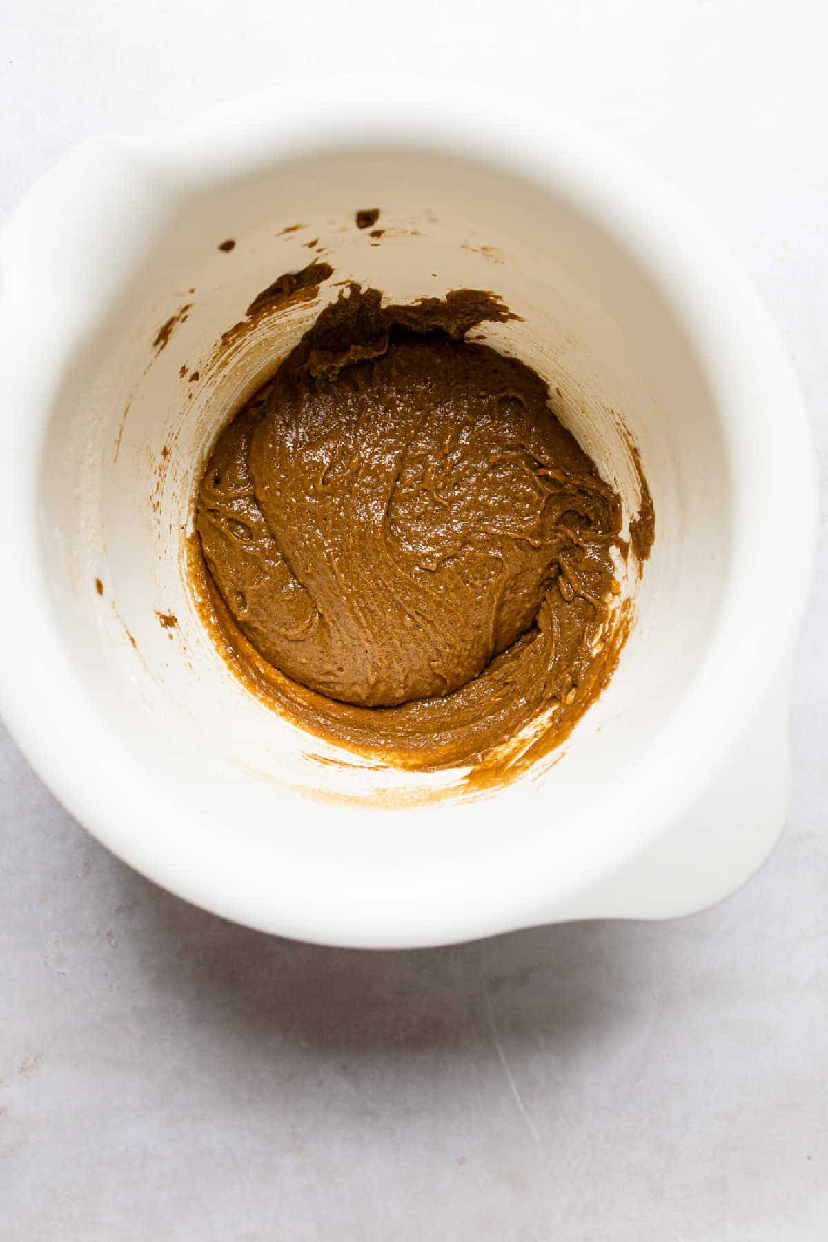 Gingerbread pudding cake batter in a mixing bowl. 