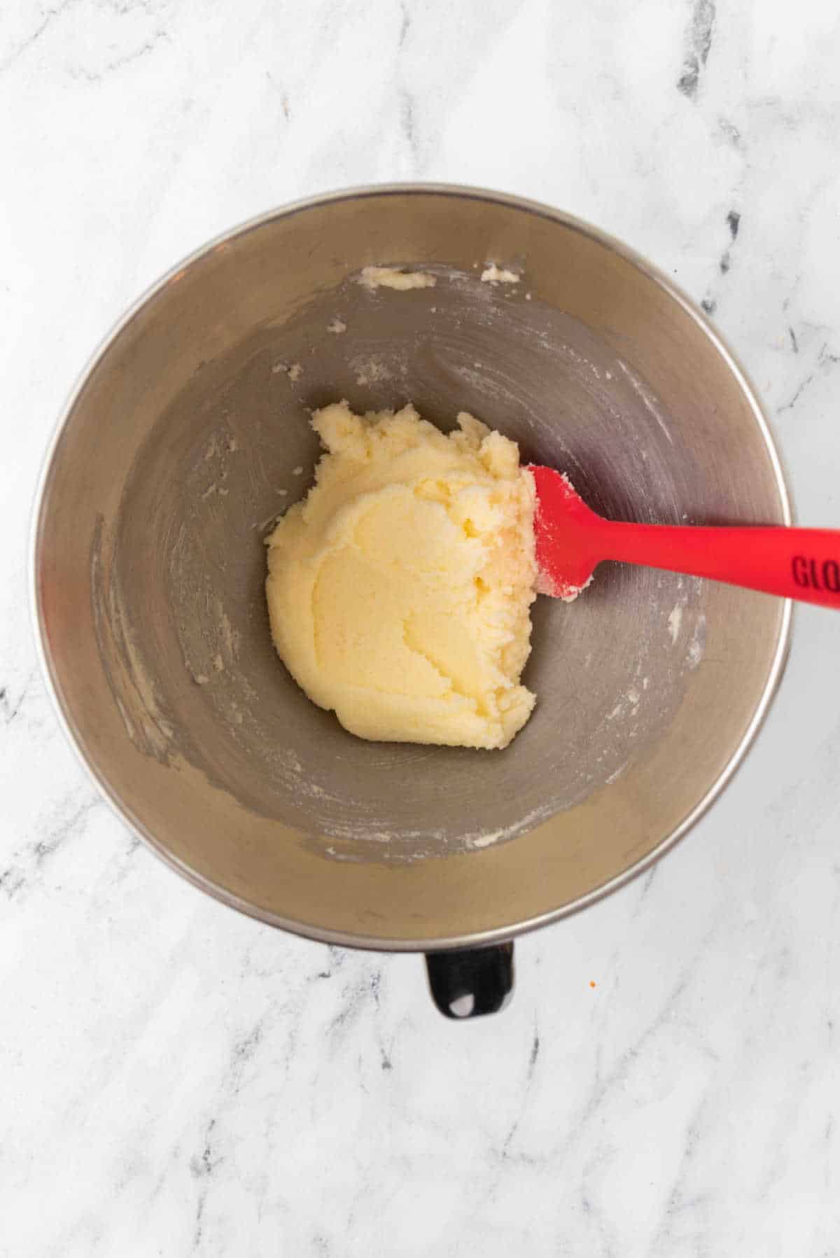 Creamed butter and sugar in a silver mixing bowl. 