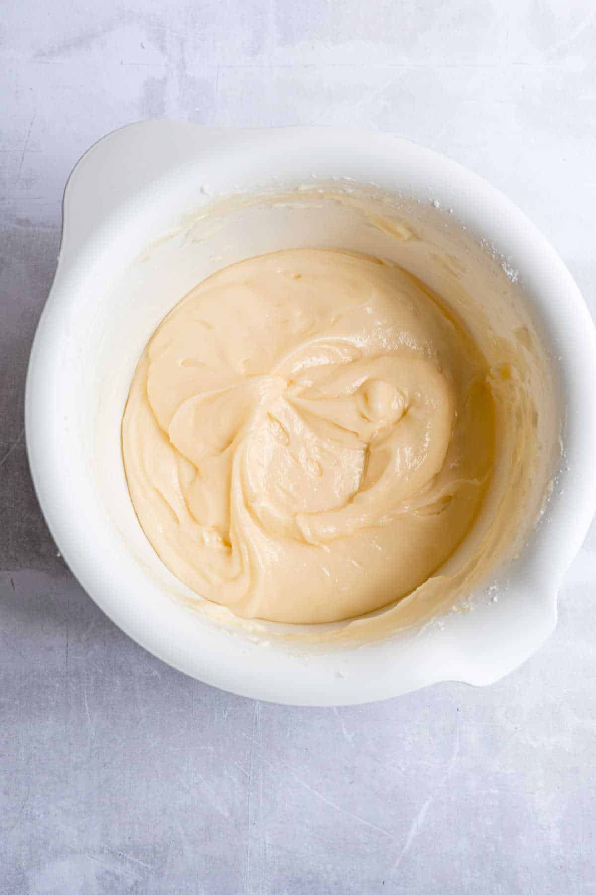 Cream cheese frosting in a white mixing bowl. 