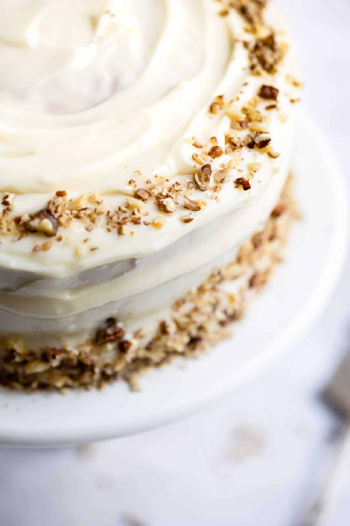 Close up shot of an Italian cream cake on a white platter. 