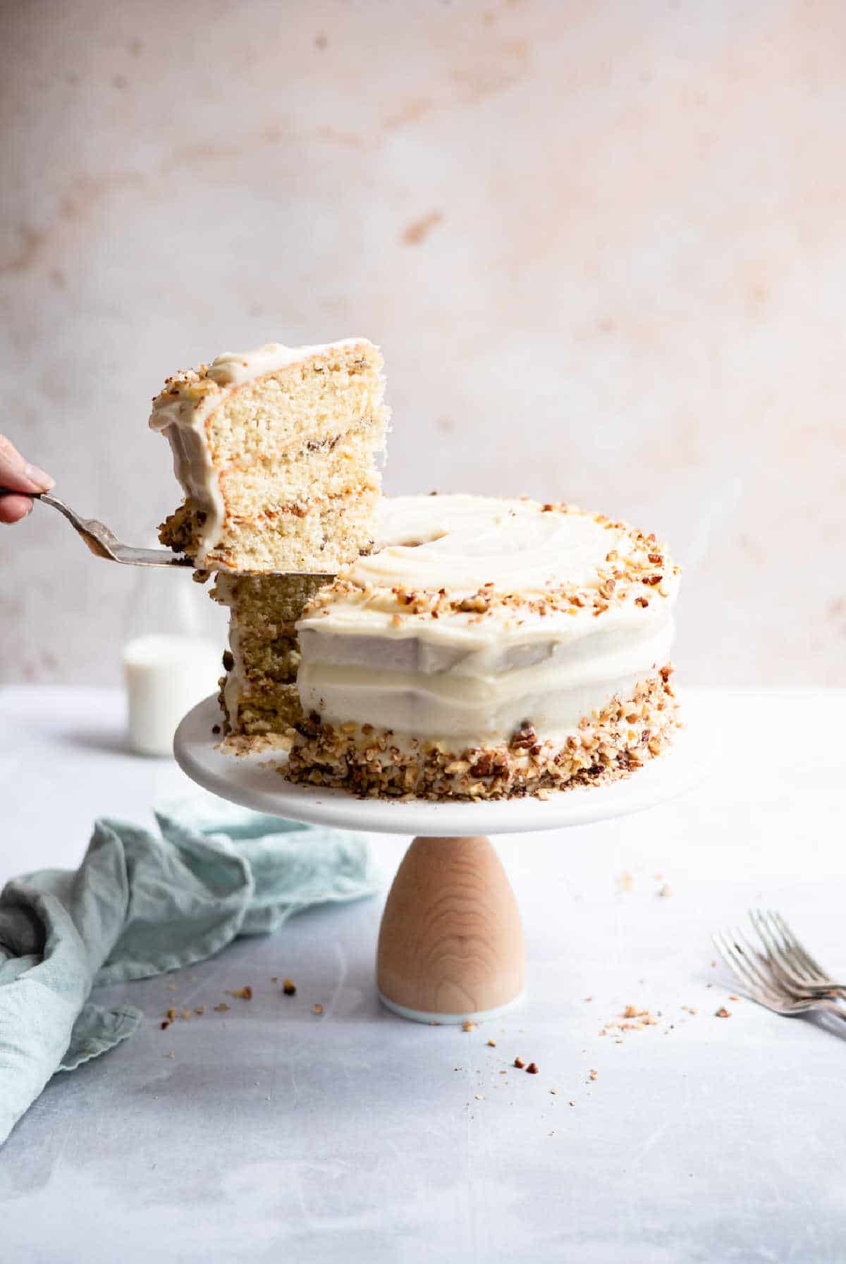 A slice of Italian cream cake being lifted from the cake. 