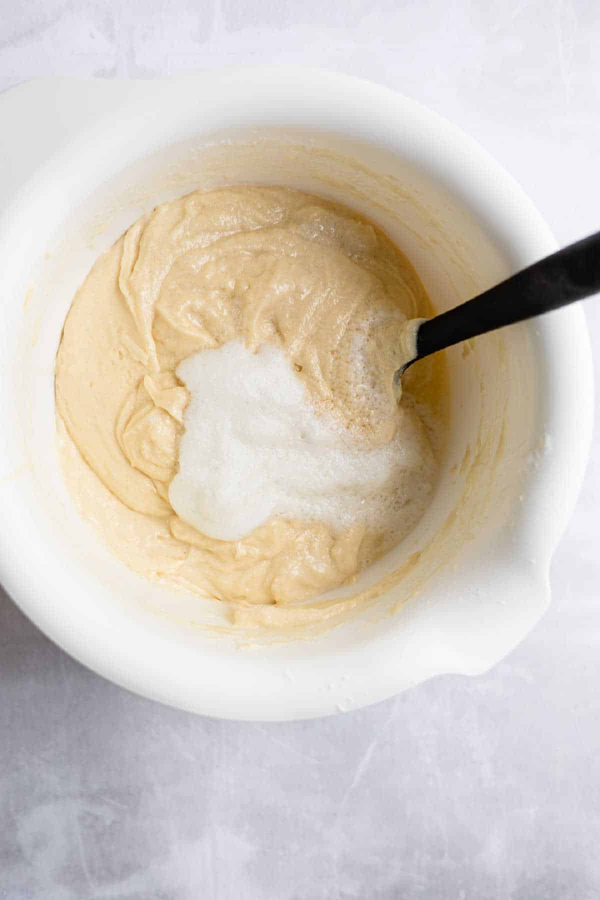 Dry ingredients and wet ingredients in a white mixing bowl. 