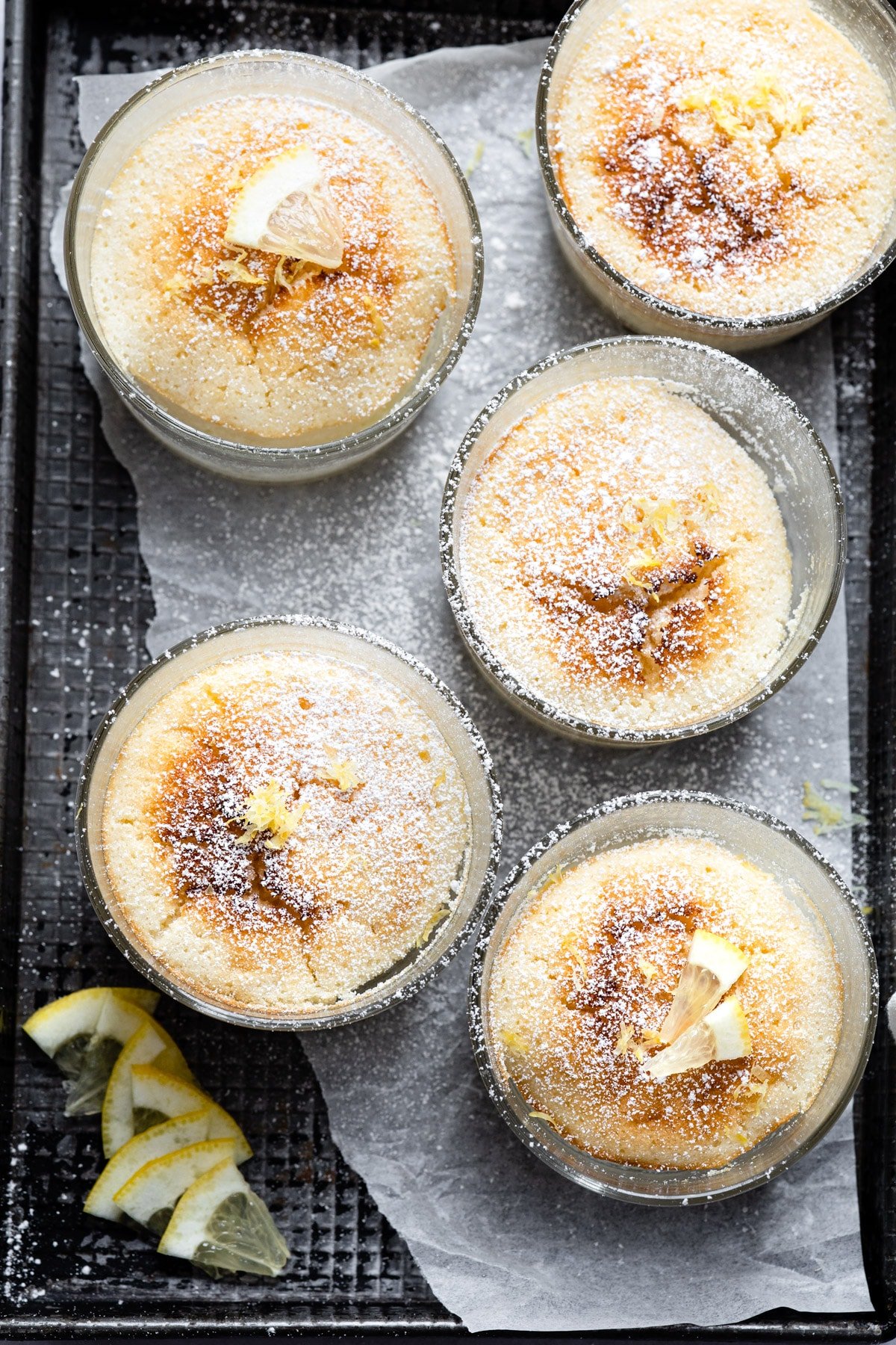 Lemon pudding cakes in glass baking dishes.