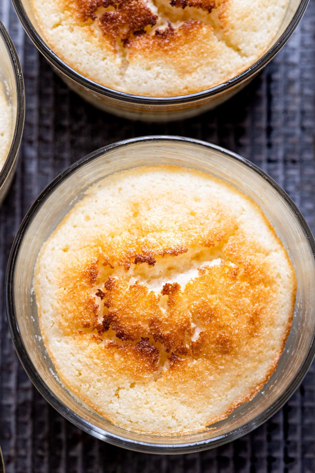 Baked lemon pudding cake in a glass ramekin.