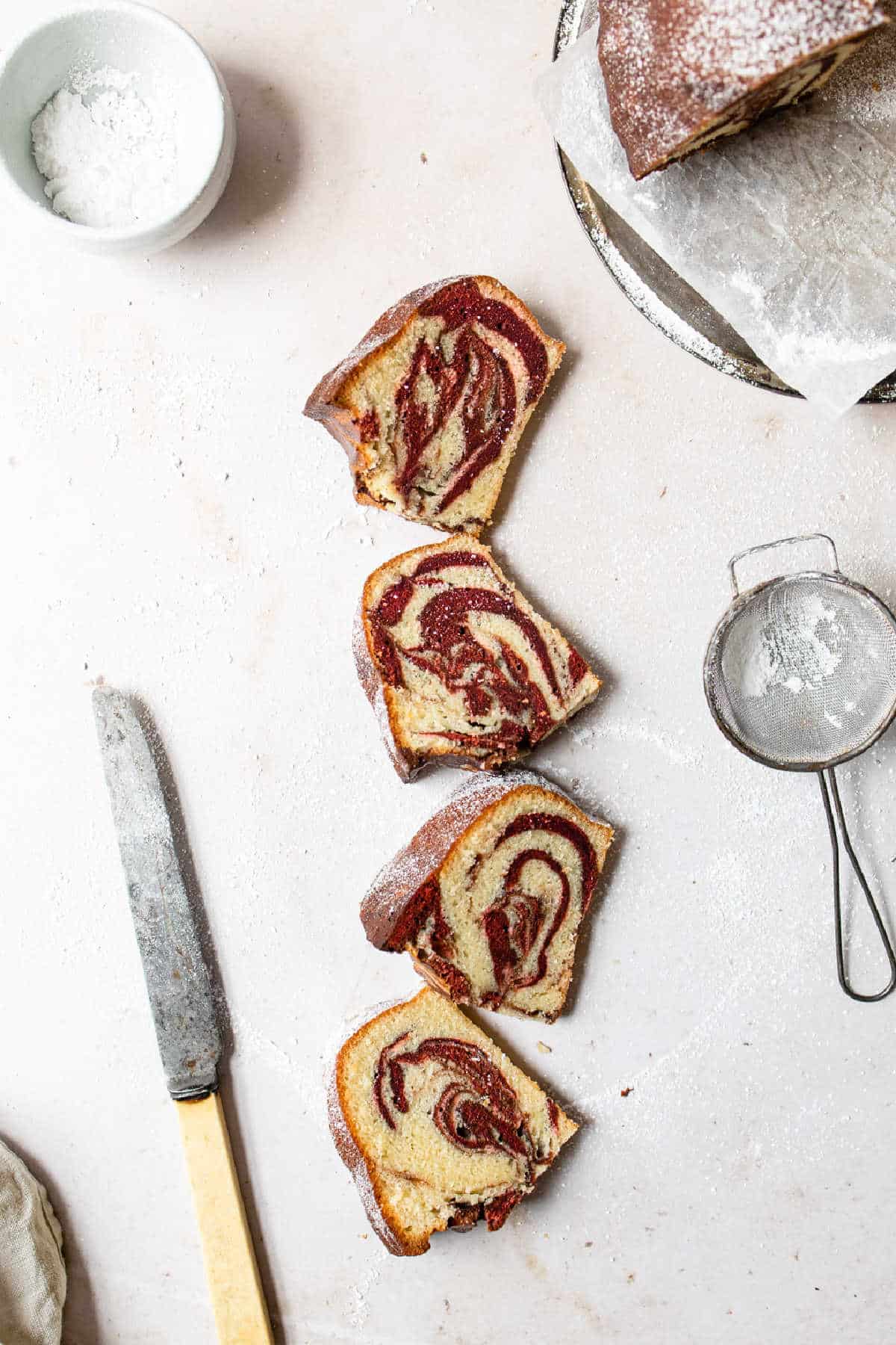 Four slices of red velvet marble cake in a row. 