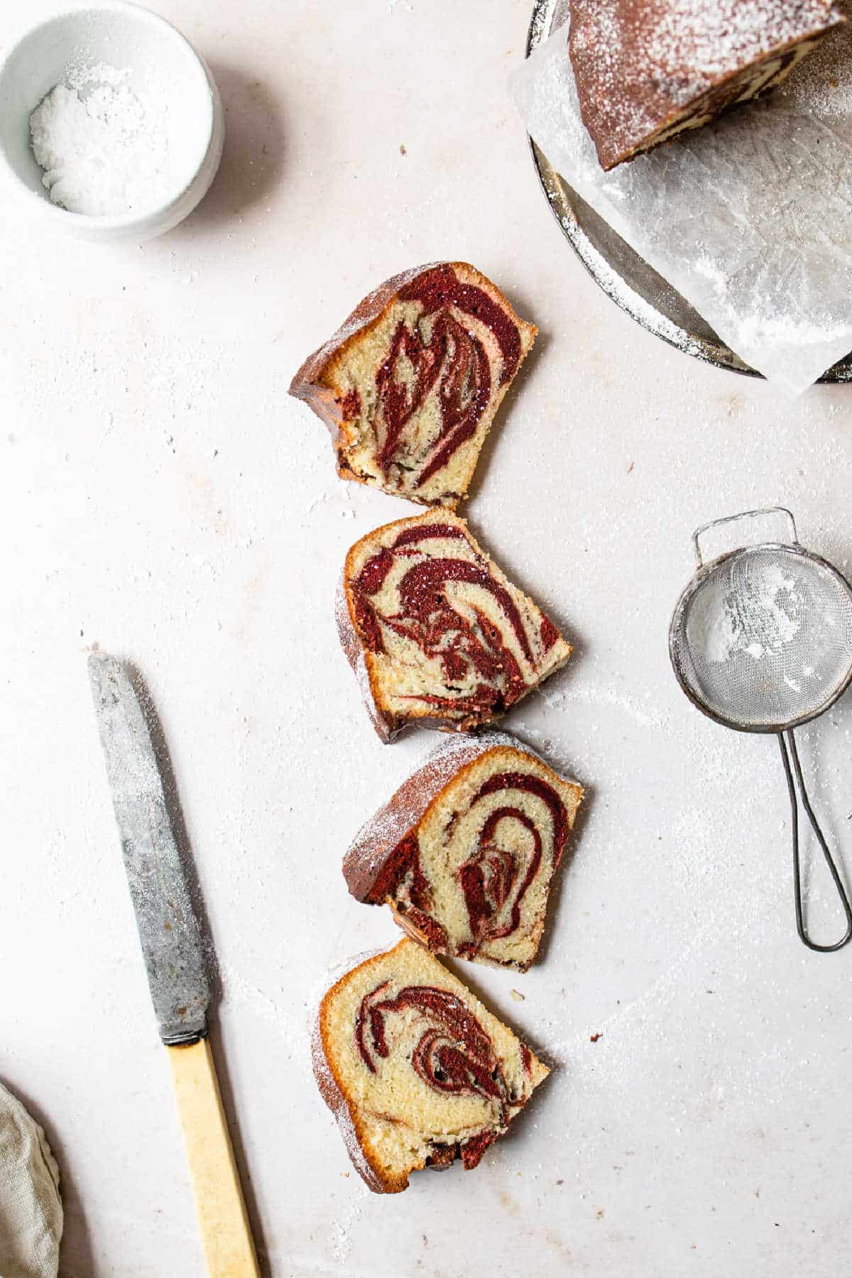 Four slices of red velvet marble cake in a row.