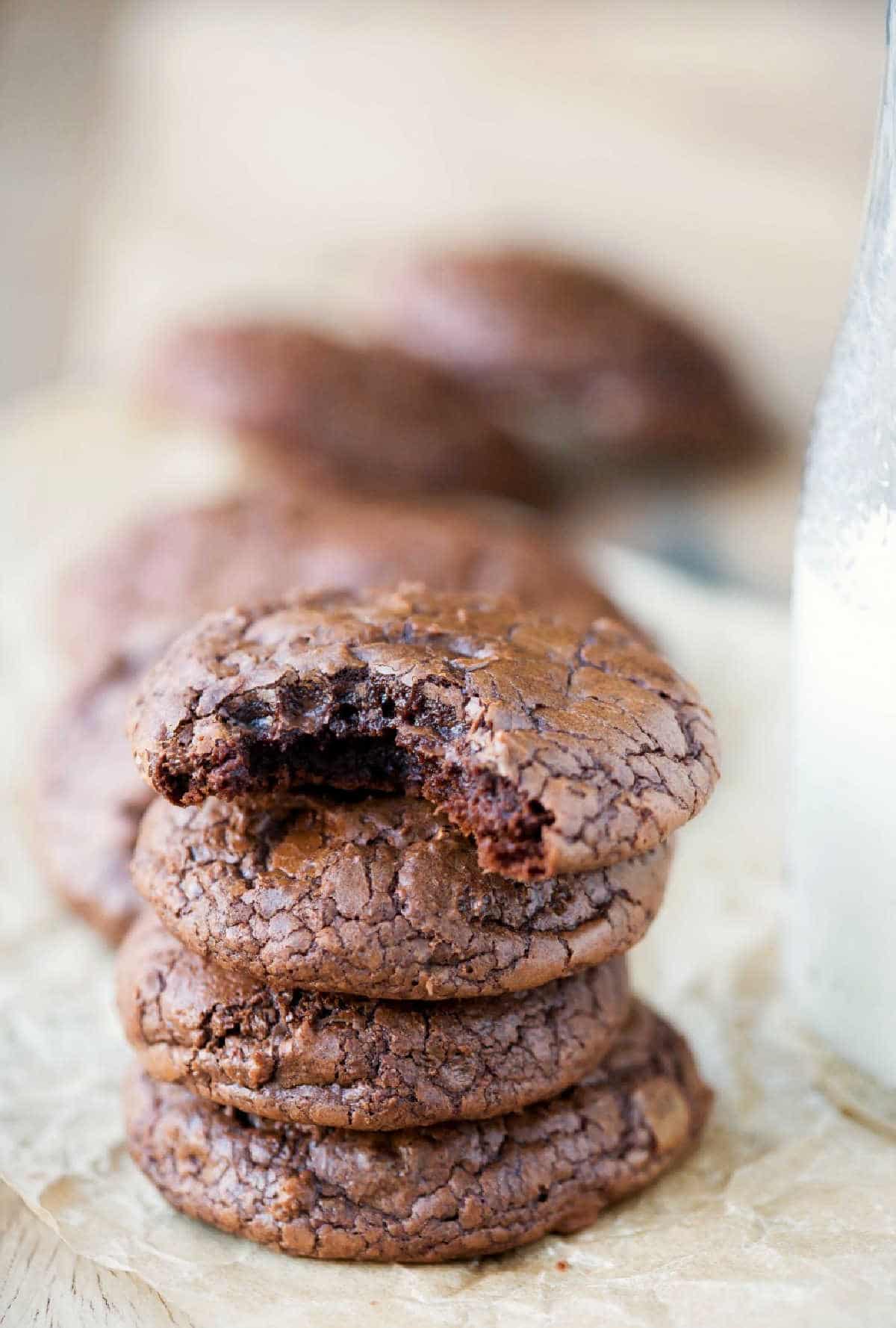 Stacks of brownie cookies on a piece of brown parchment paper. 