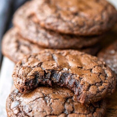 A brownie cookie with a bite missing leaning on another brownie cookie.