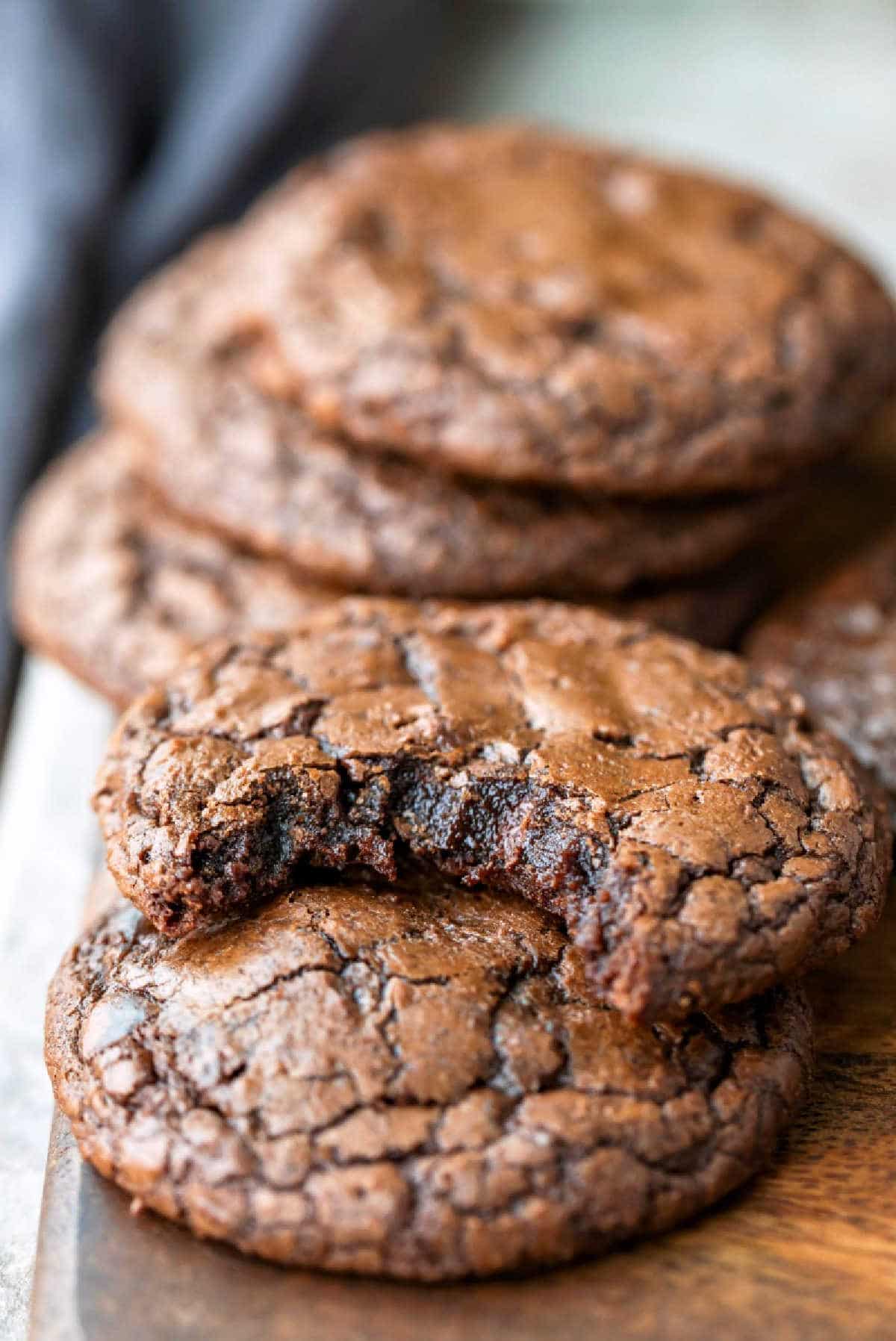 A brownie cookie with a bite missing leaning on another brownie cookie.