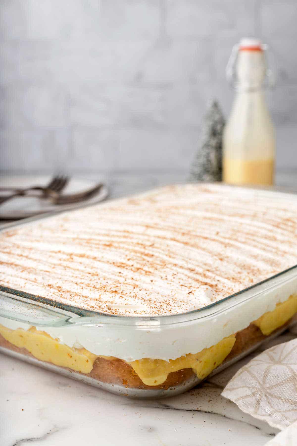 An eggnog poke cake in a glass baking pan. 