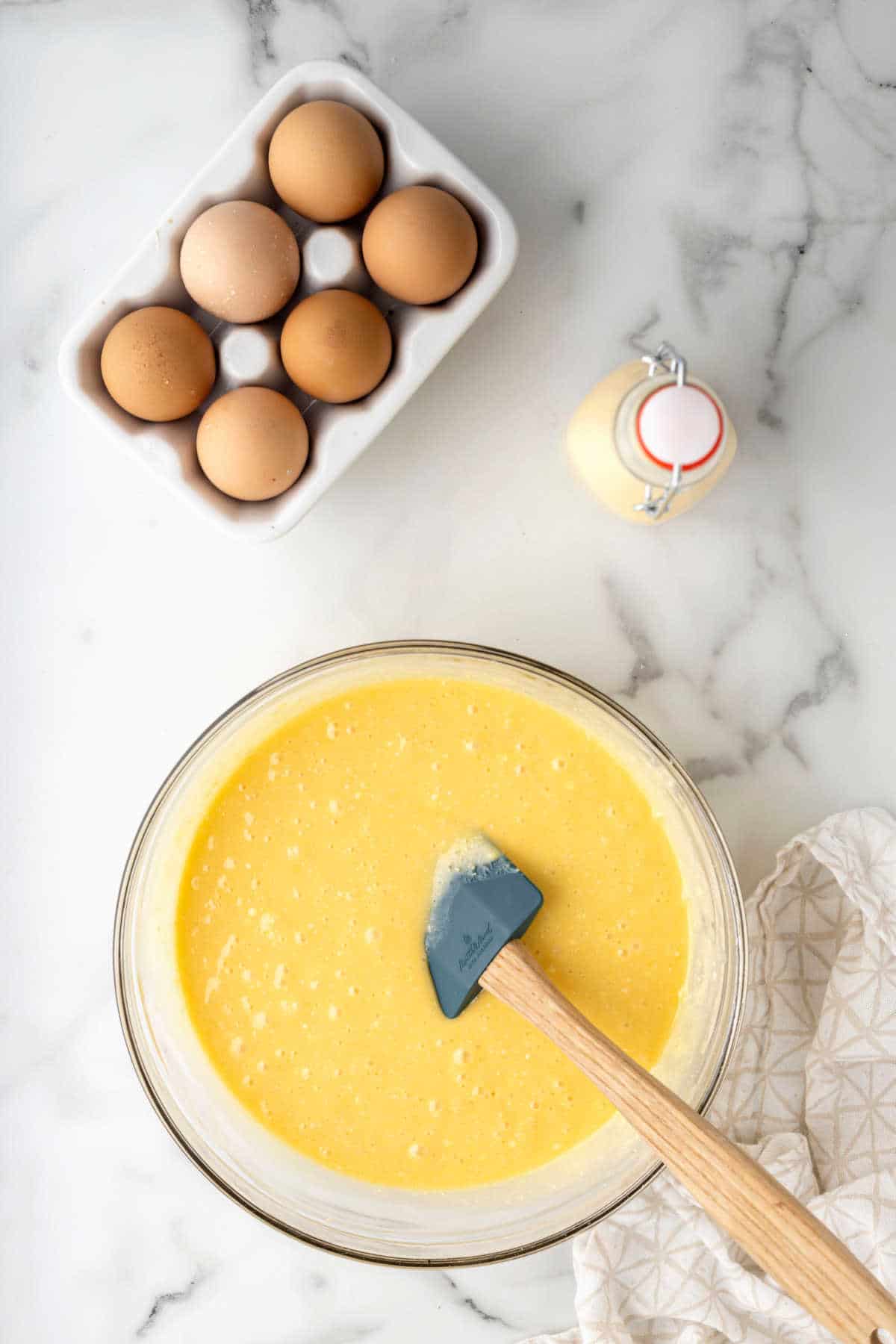 Yellow cake batter in a glass mixing bowl. 