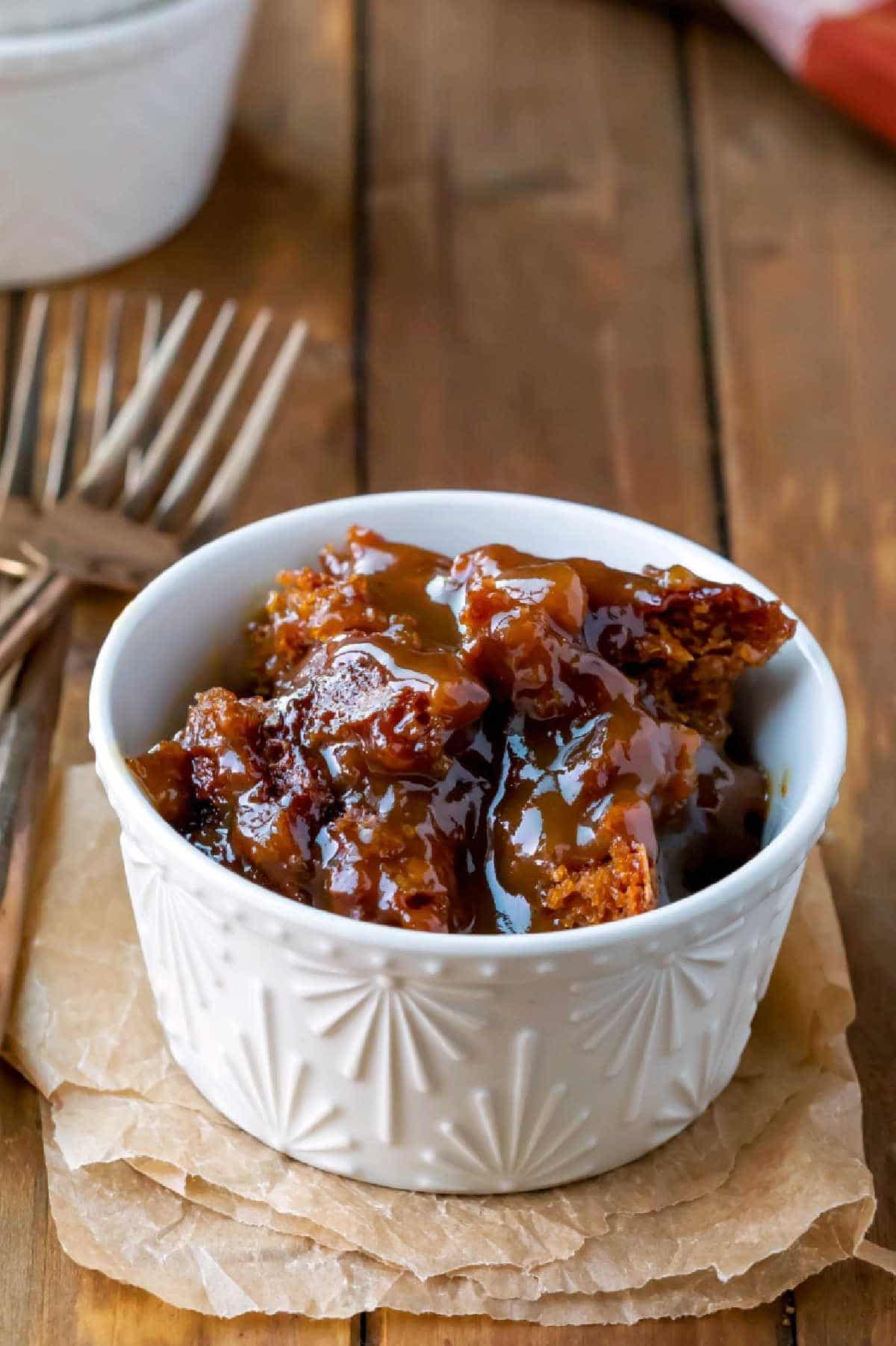 A cream ramekin with gingerbread pudding cake in it. 