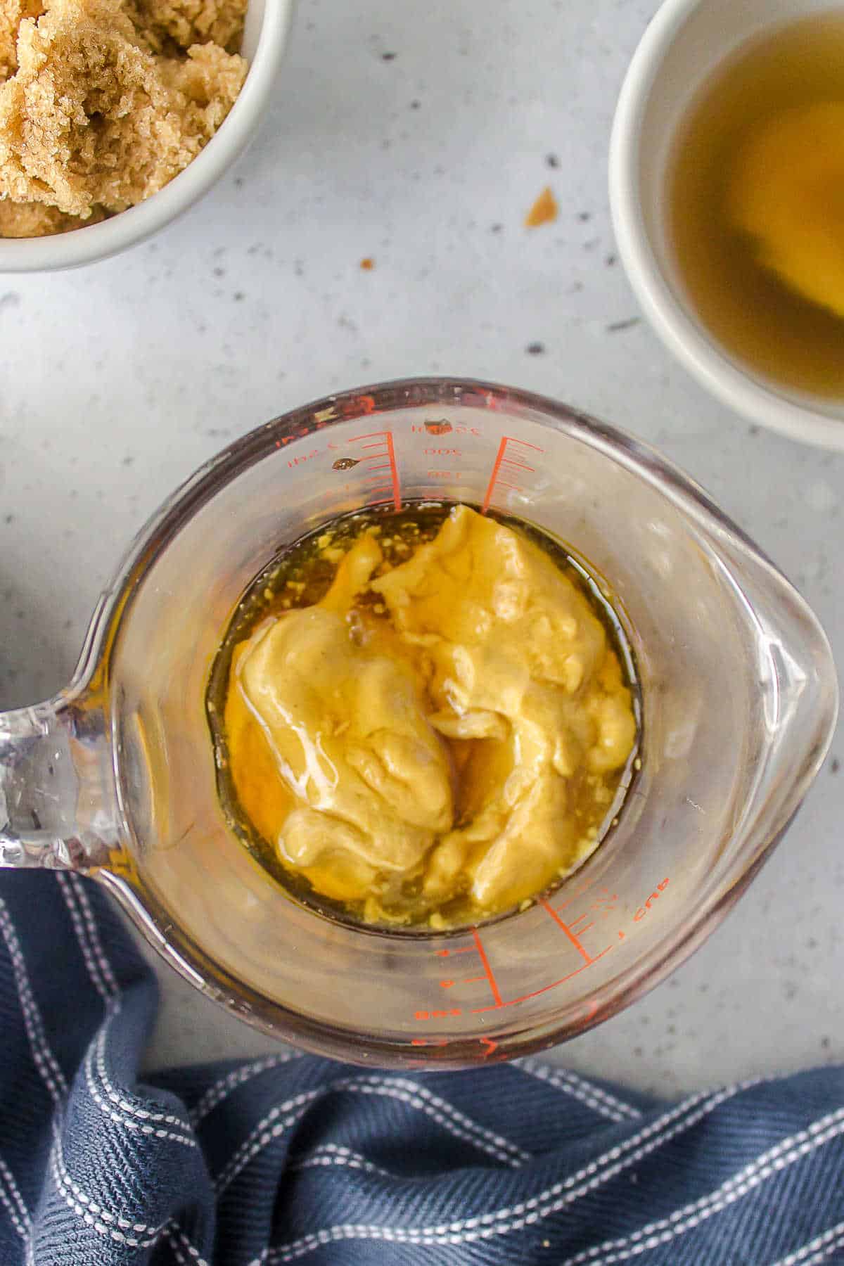 Ingredients for maple glaze in a glass measuring cup. 