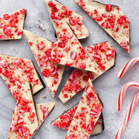 Peppermint bark next to three candy canes.