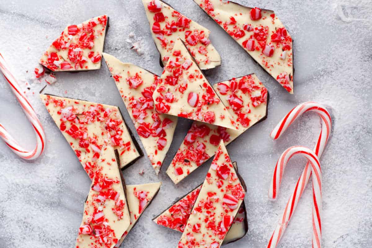 Peppermint bark next to three candy canes.