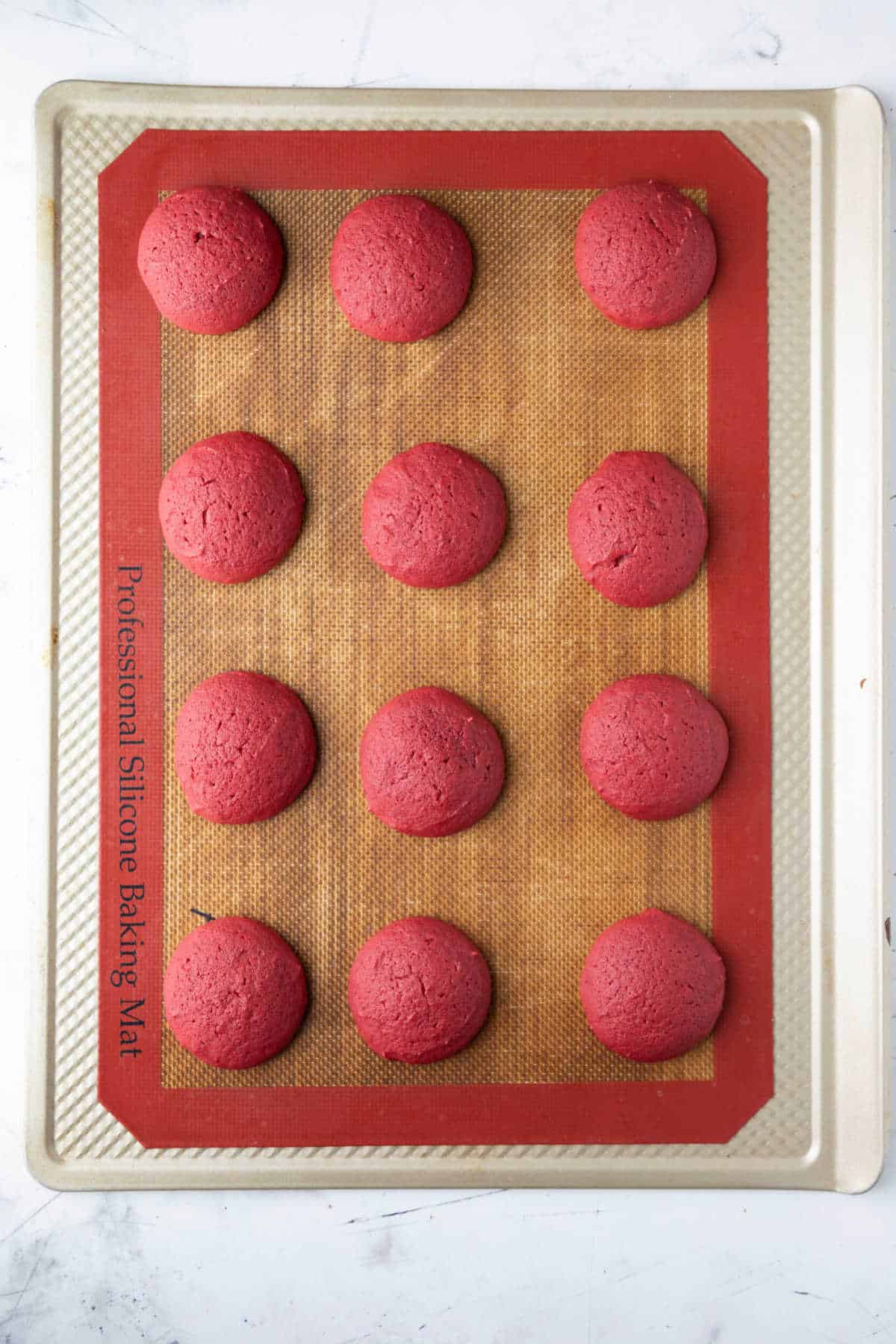 Baked red velvet cookies on a baking sheet. 