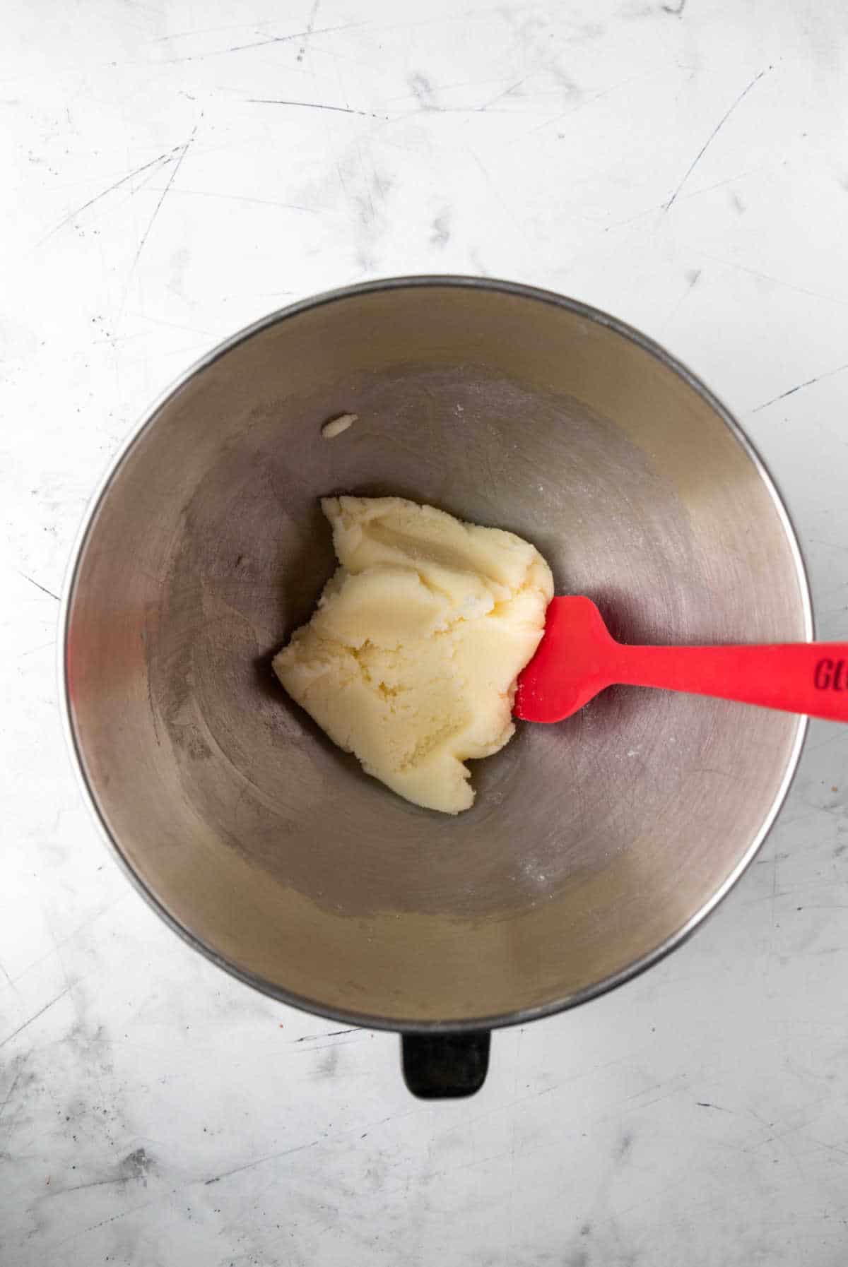 Creamed butter and sugar in a silver mixing bowl. 