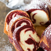 Slices of red velvet marble cake on a wooden serving platter.