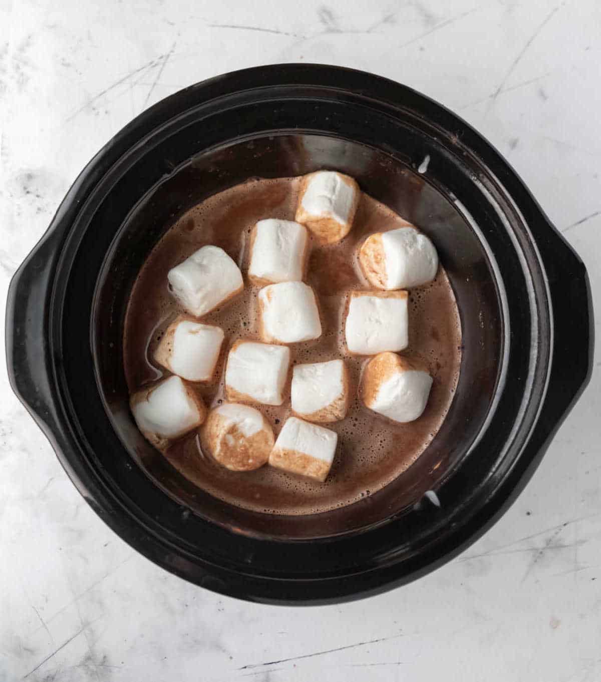 Slow cooker insert full of hot chocolate and marshmallows. 