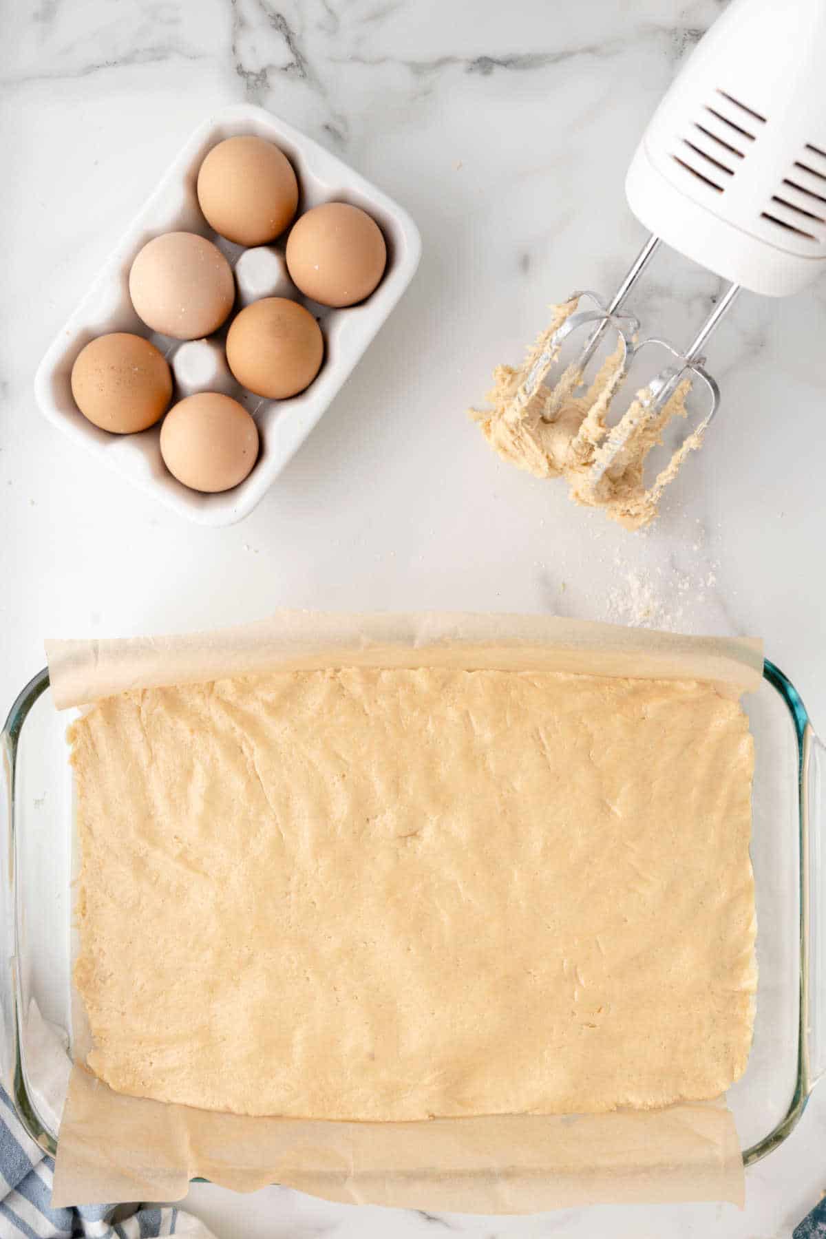 Sugar cookie bar dough in a glass baking pan. 