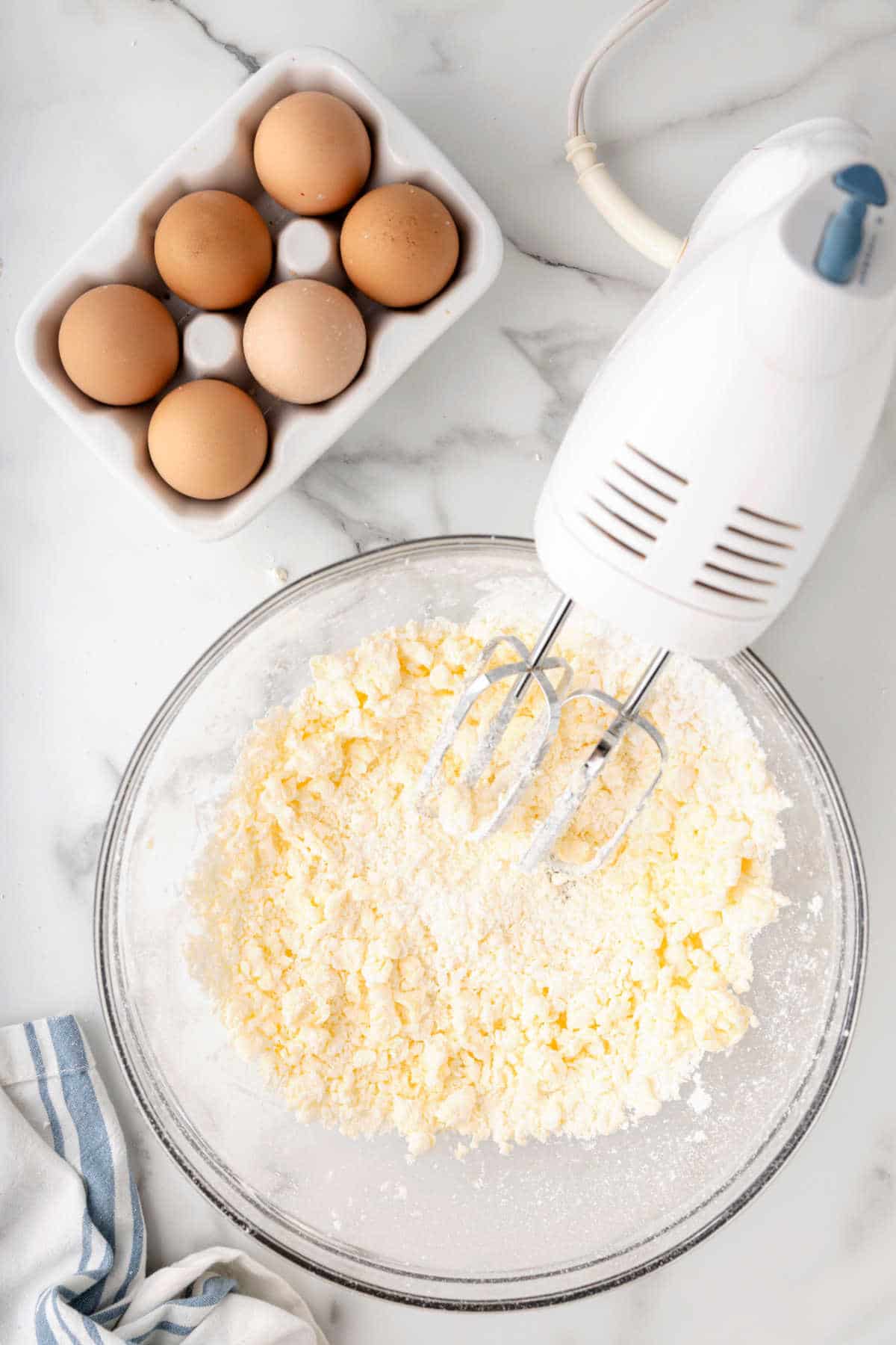 Butter and powdered sugar beaten together in a glass mixing bowl.