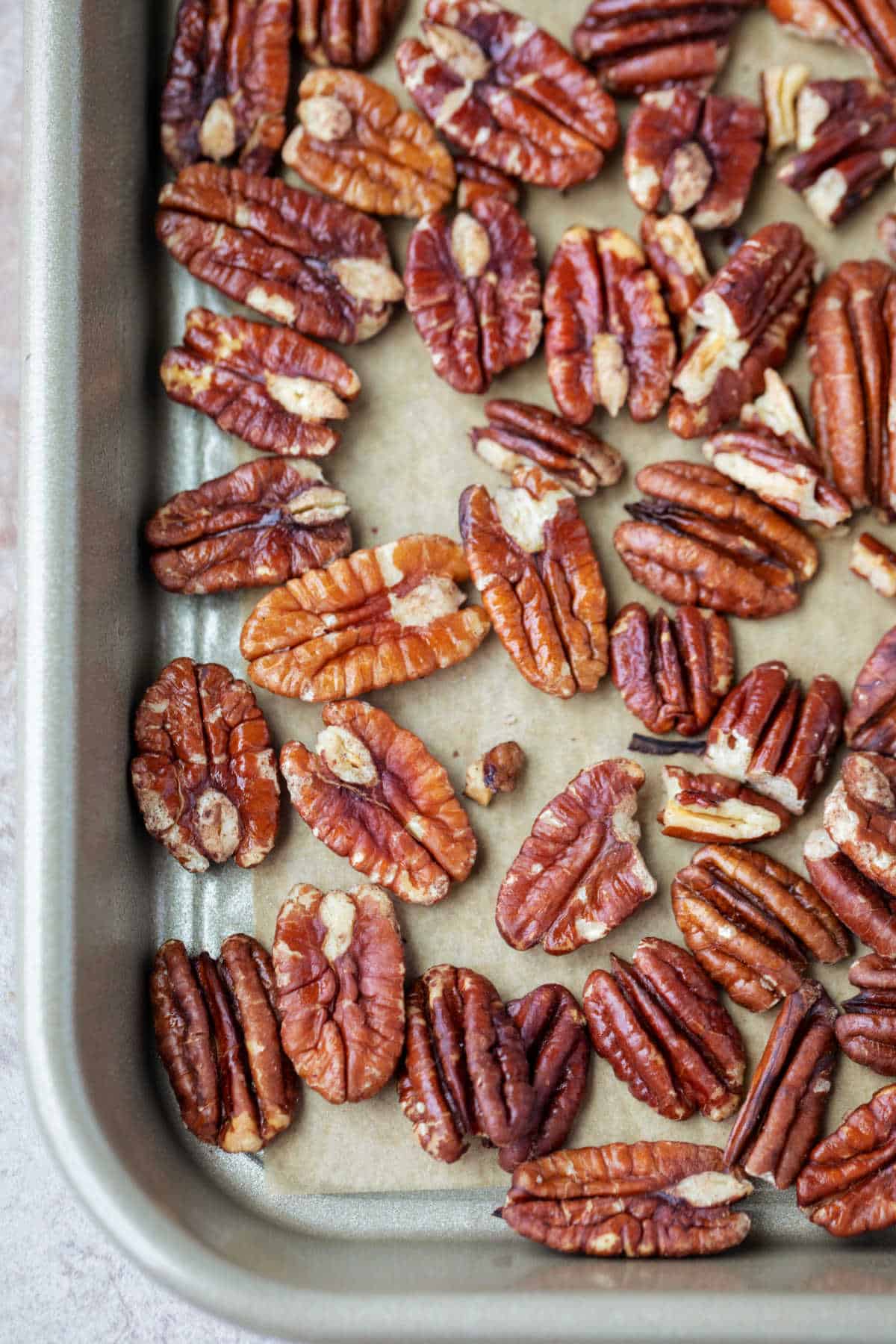 Rimmed baking sheet with toasted pecans on it.