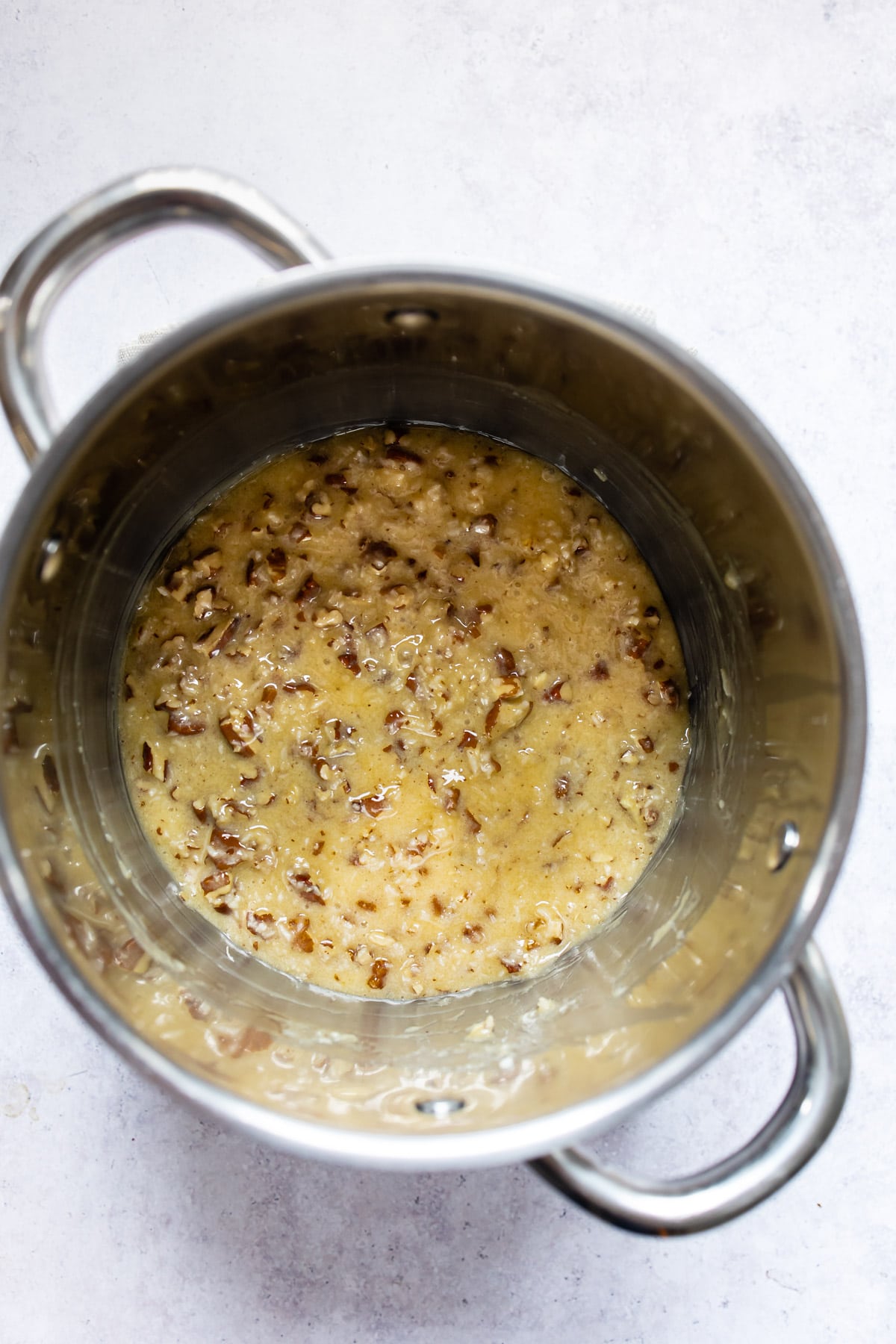 Coconut pecan frosting in a silver pot. 