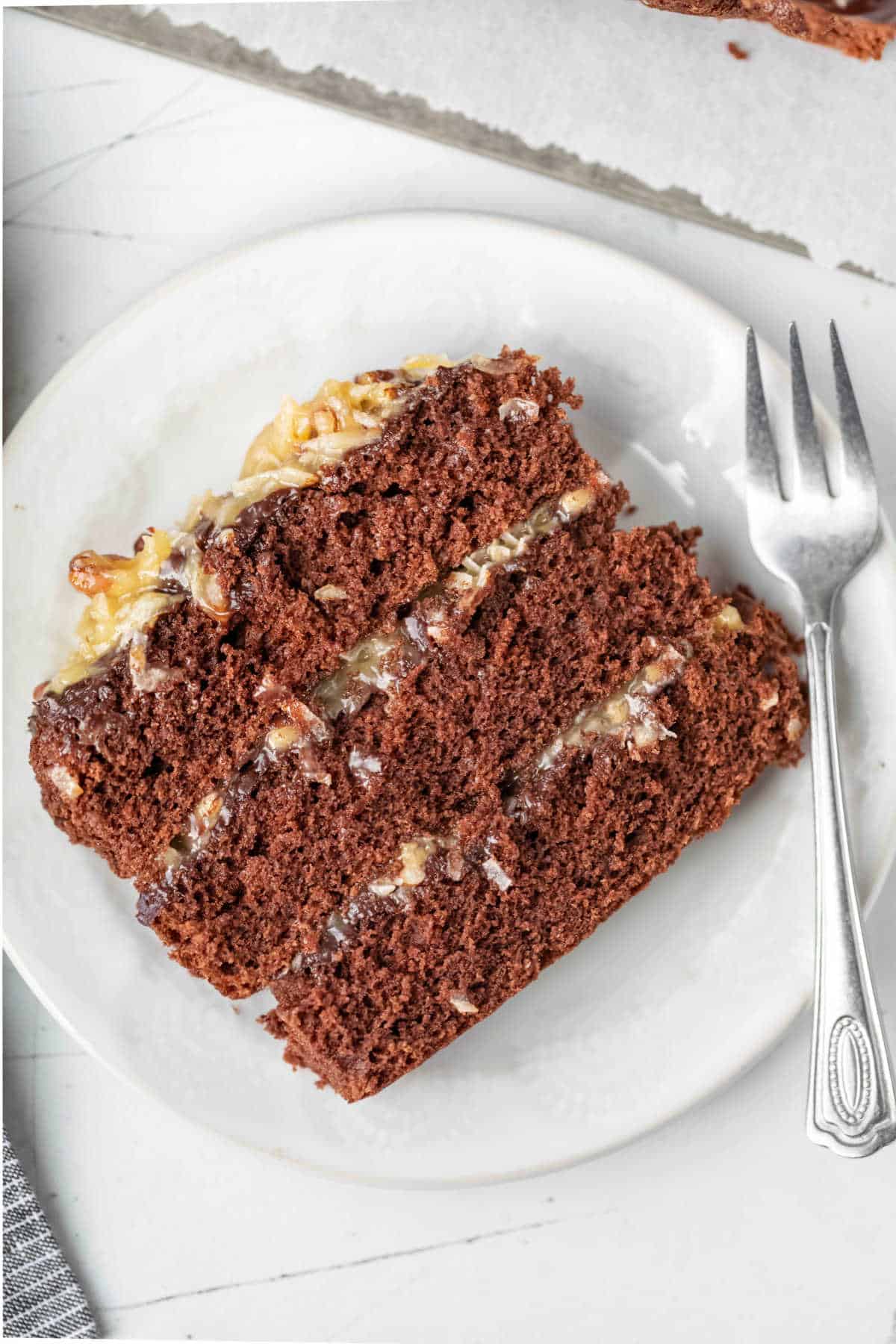 A slice of german chocolate cake on a white plate.