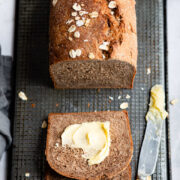 Loaf of outback bread with two slices buttered and cut.