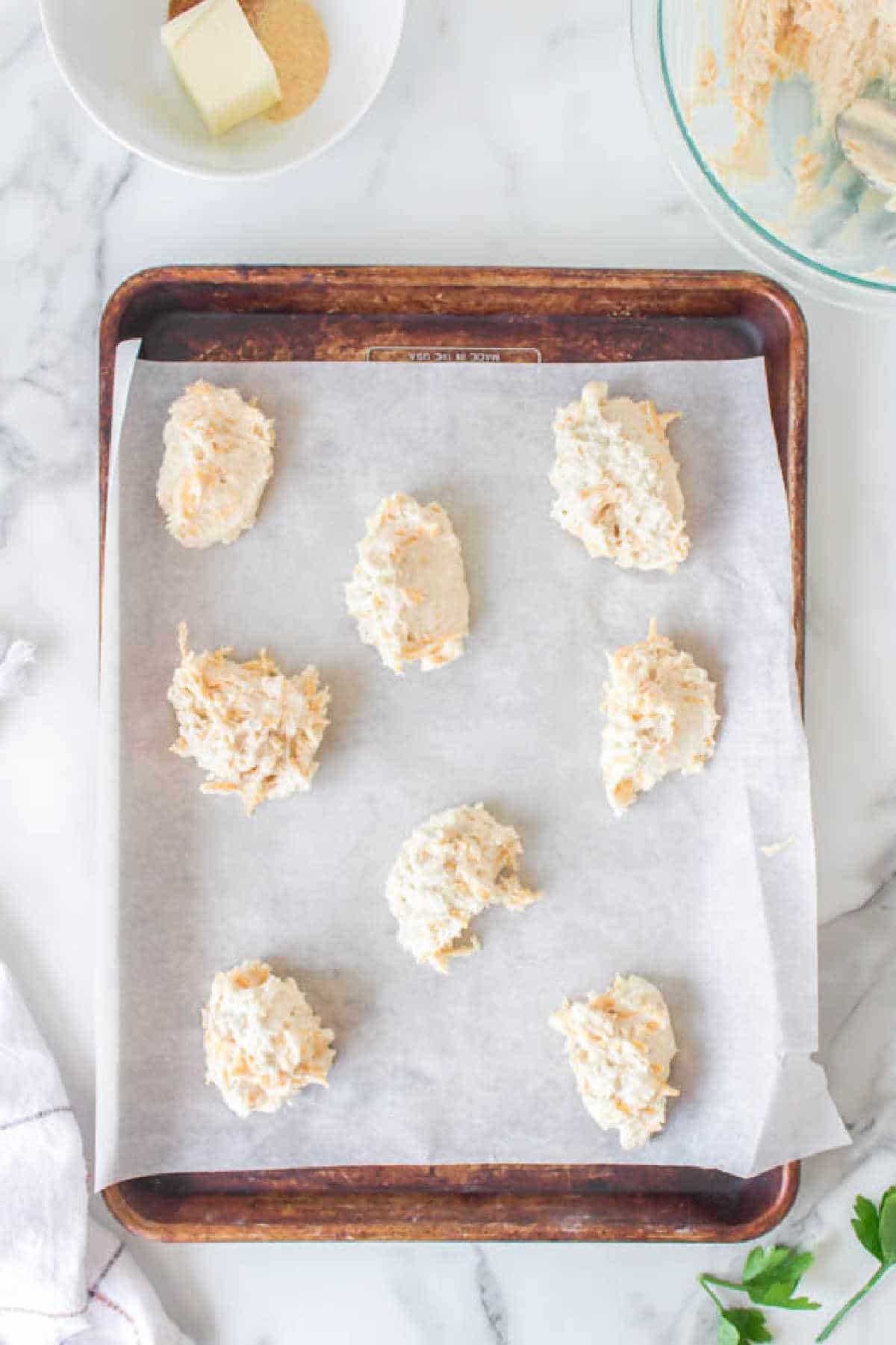 Cheddar bay biscuit dough on a baking sheet.
