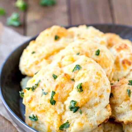 Dish of cheddar bay biscuits on a wooden background.