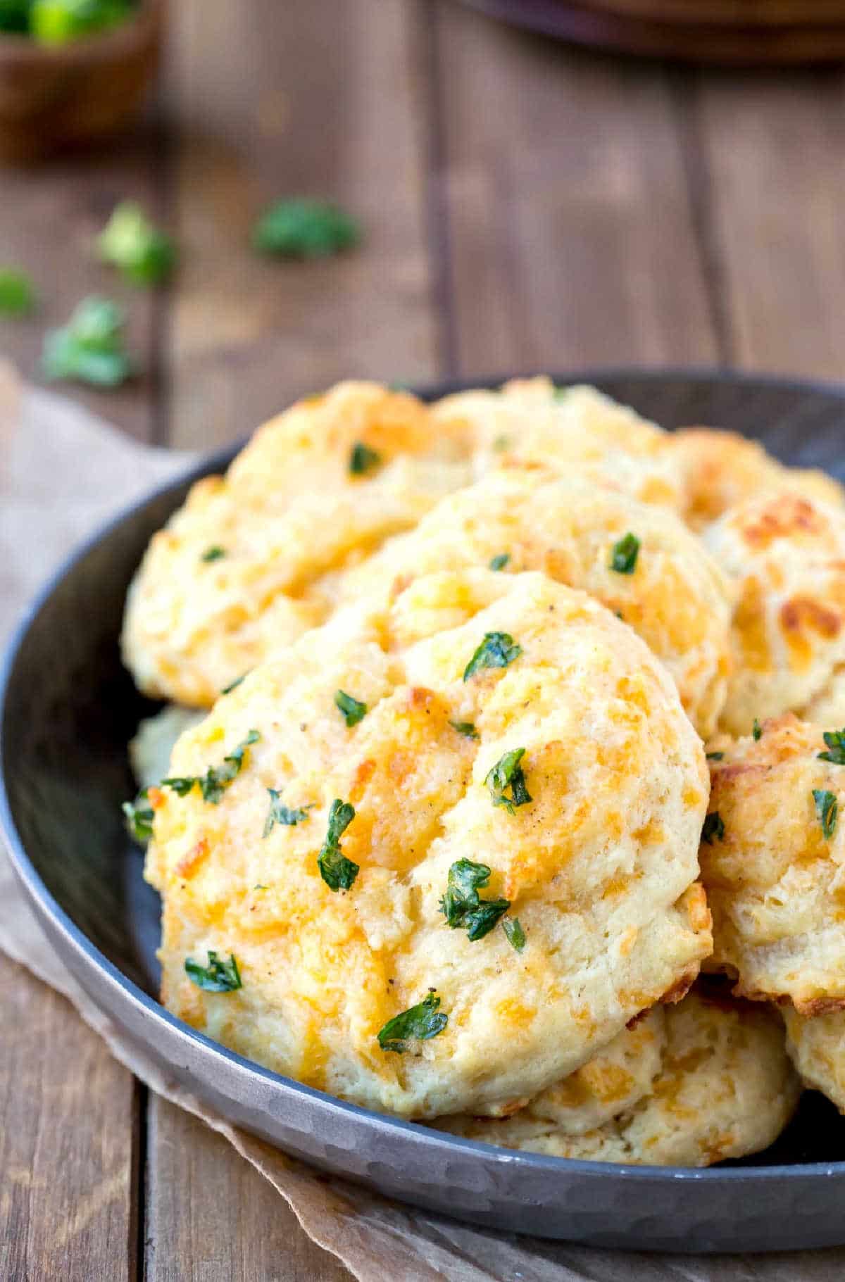 Dish of cheddar bay biscuits on a wooden background.