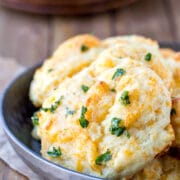Silver dish full of cheddar bay biscuits.