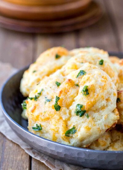 Silver dish full of cheddar bay biscuits.