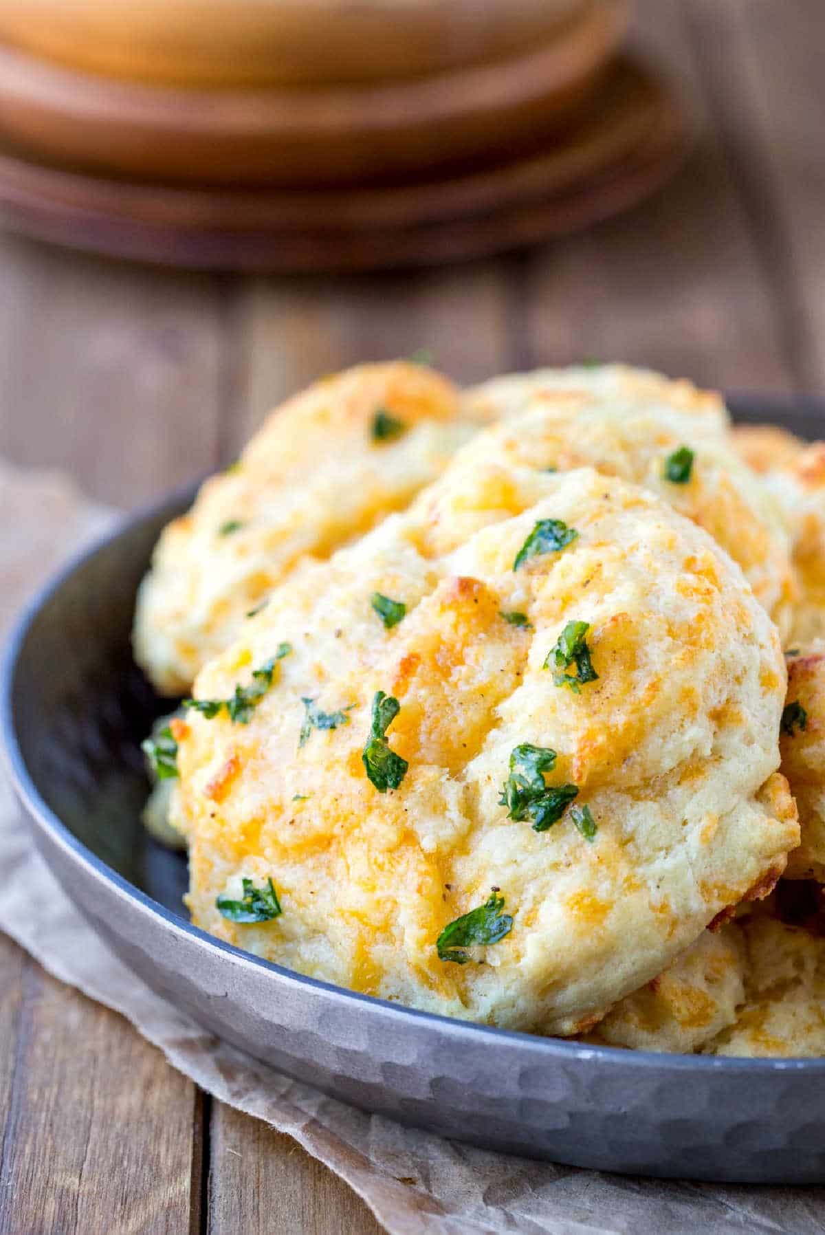 Silver dish full of cheddar bay biscuits.