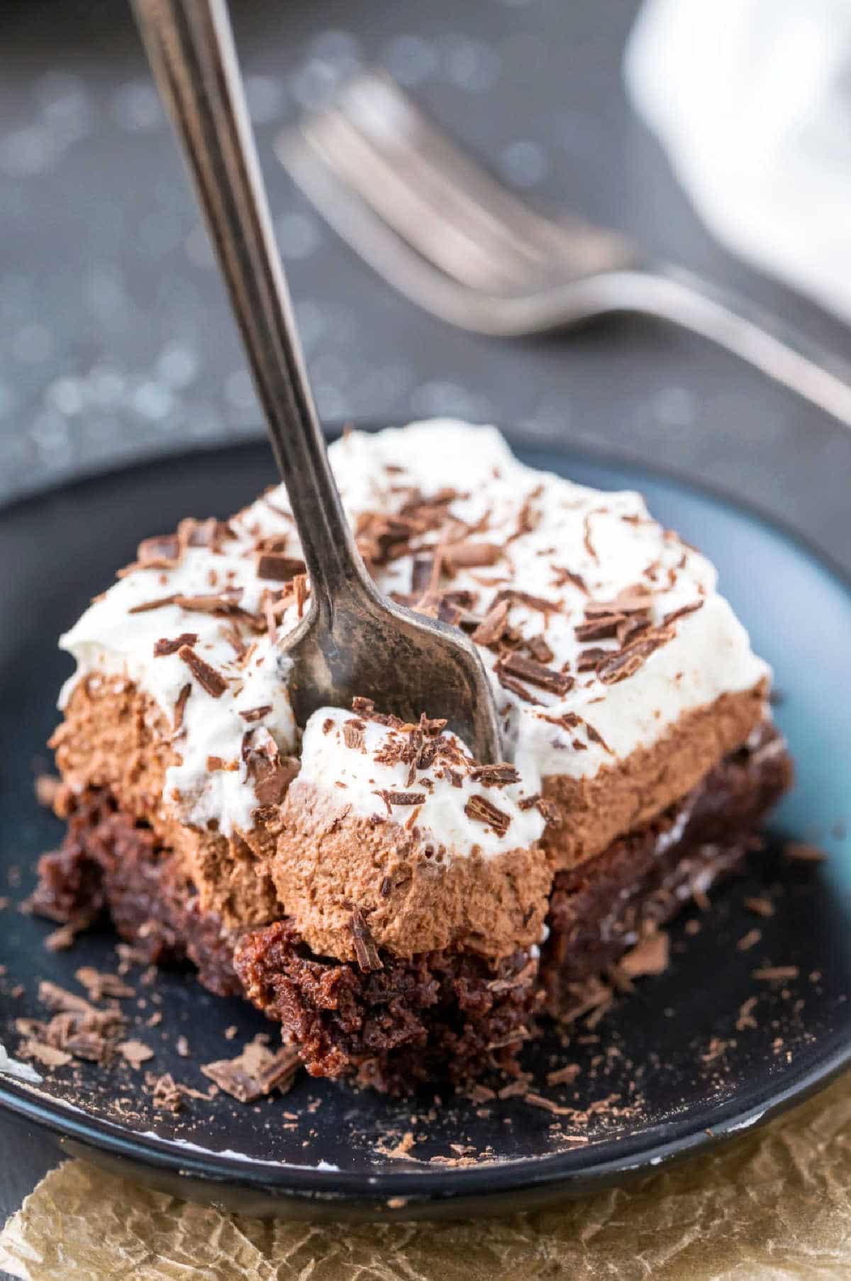 Silver fork taking a bite of a French silk brownie. 