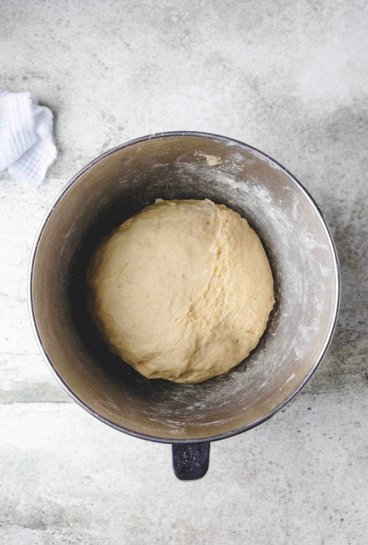 Garlic knot dough in a silver mixing bowl. 