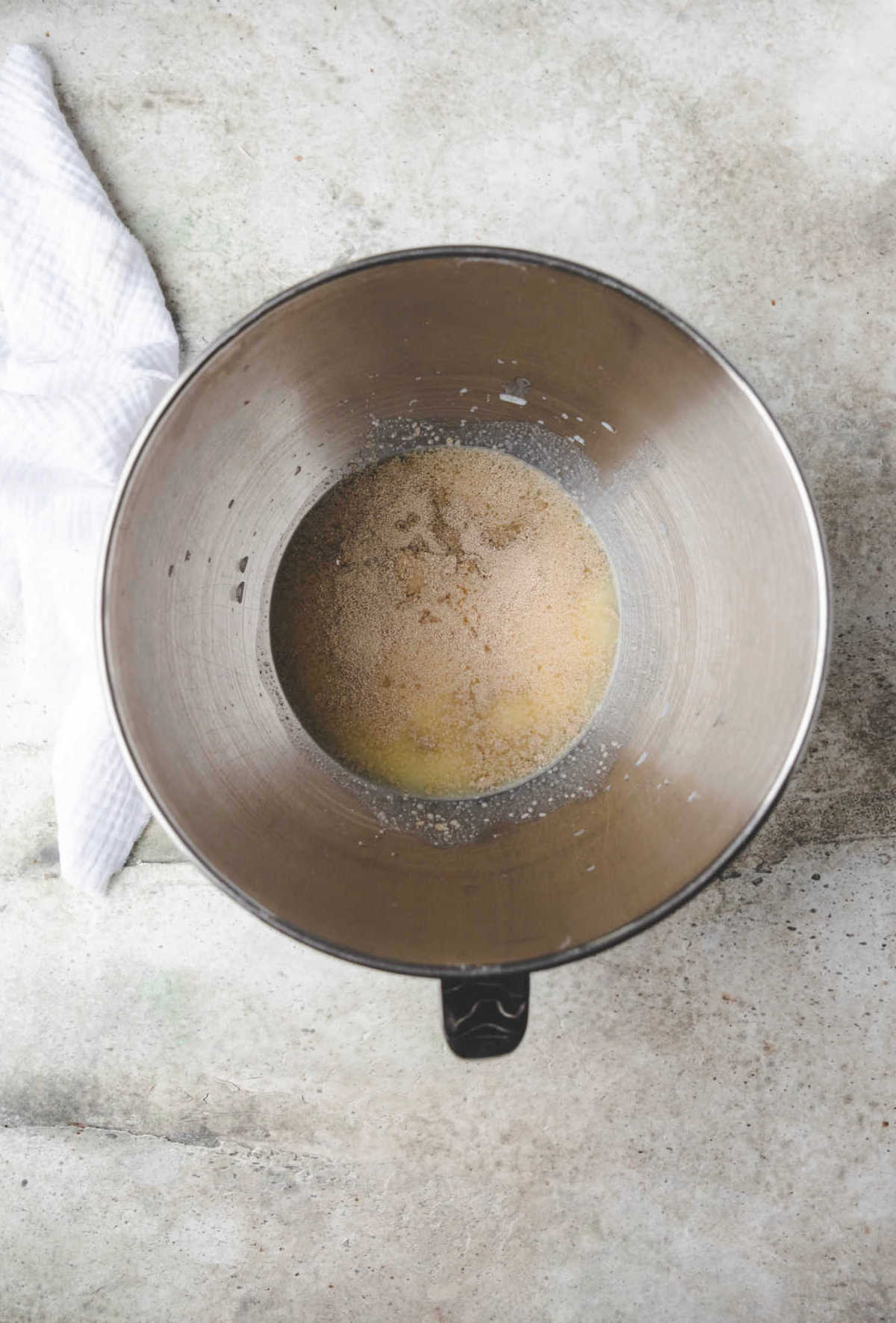 Yeast honey butter and milk in a silver mixing bowl. 