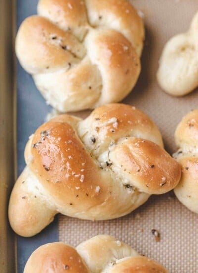 Close up photo of a garlic knot on a baking sheet.