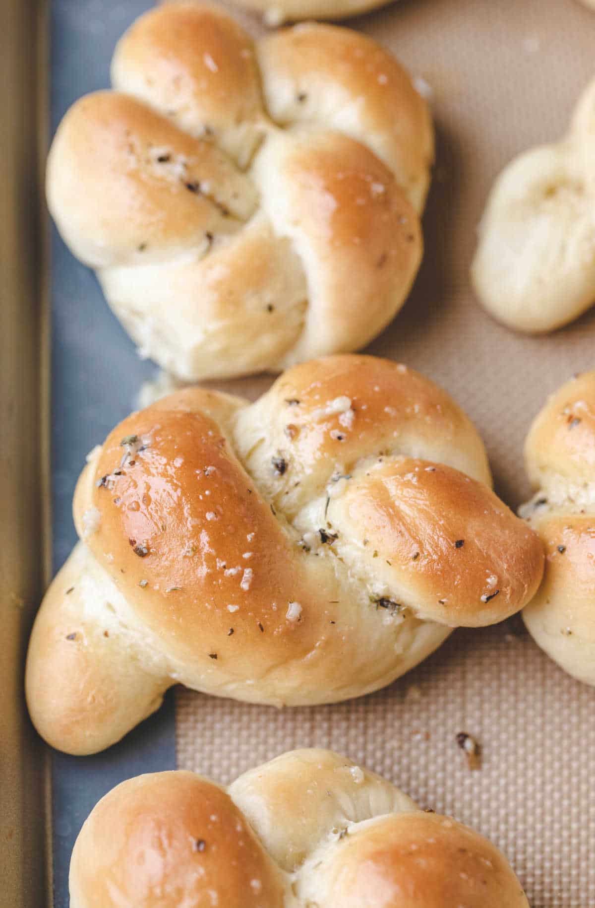 Close up photo of a garlic knot on a baking sheet. 